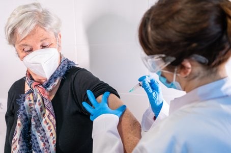 Woman receives vaccine from nurse