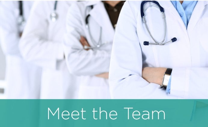 Meet the Team - doctors in their white coats standing in line with arms crossed